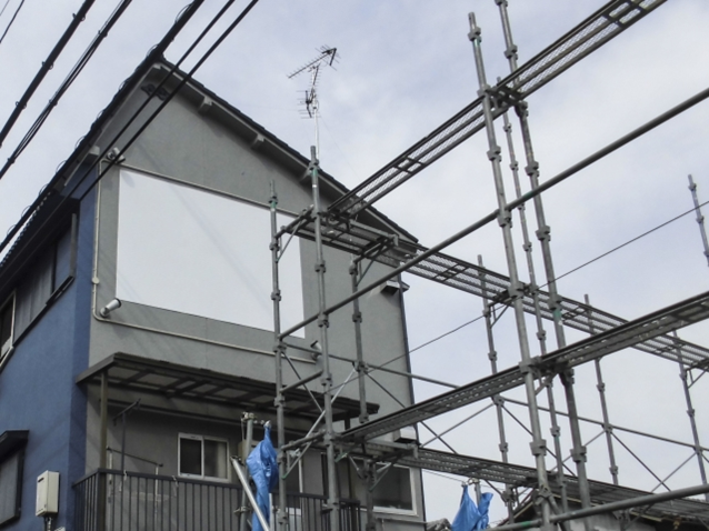足場が立てられている壁面看板の制作風景の写真
