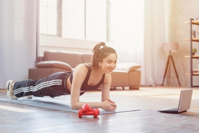 トレーニングマットの上で体幹トレーニングをする女性