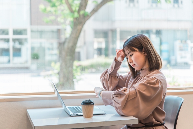 窓際で仕事をする忙しい女性
